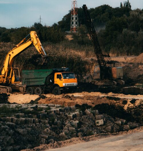 A closeup shot of an ongoing construction  with tracks and a bulldozer on an  abandoned land